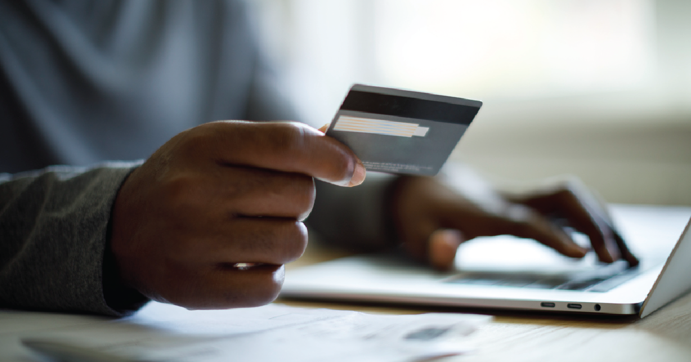 Pre-visit billing strategies - Man holding a credit card while accessing prices of medical services online.