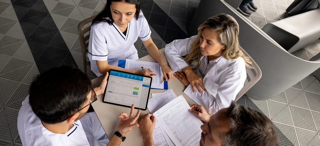 group-of-medical-specialists-discussing-patient's-medical-record-on-tablet