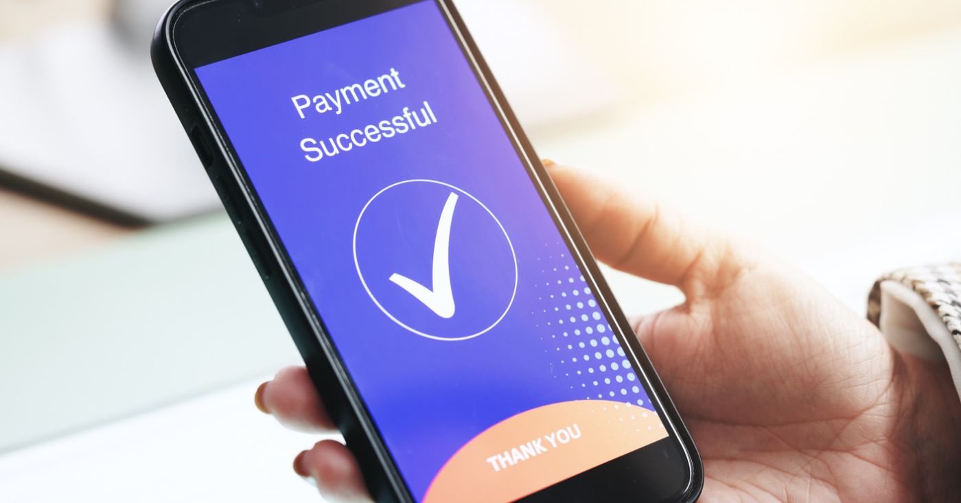 Patient Payment Experience: Confirmation of successful payment on smartphone screen in person’s hand.