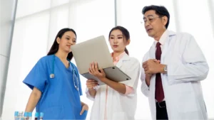 A group of doctors looking at a computer talking about their healthcare revenue cycle