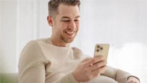 A man looking at his phone participating in secure patient messaging with his provider