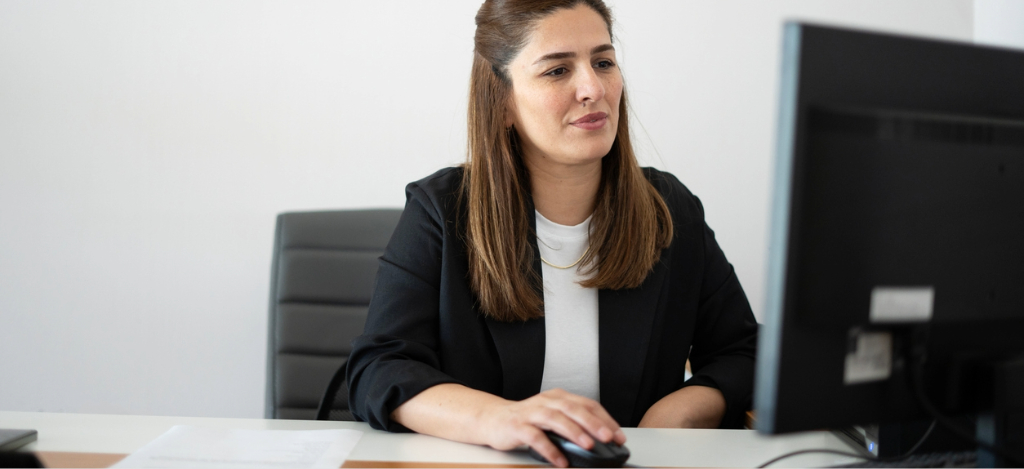 Text to Pay - A female practice administrator using a computer to check their healthcare billing solution.