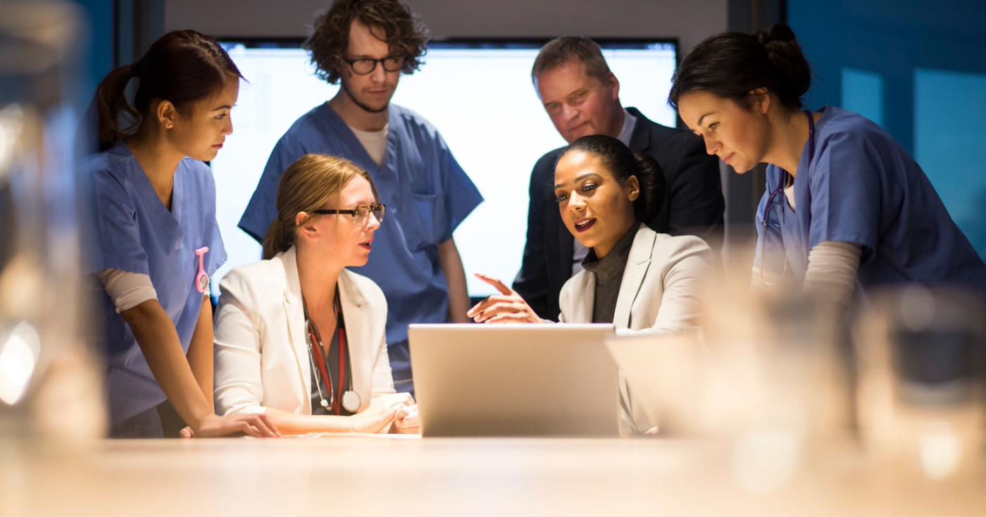 Revenue cycle partner - A group of medical professionals discussing modern billing software with their business partners.