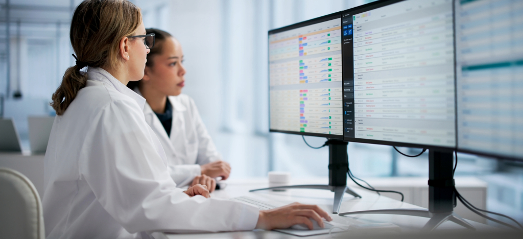 RCM medical billing - Two female hospital staff members looking at patient bills using a computer.