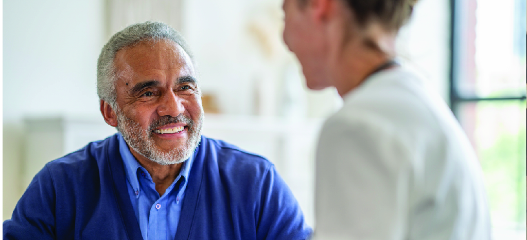 Communicating patient financial responsibility - A female medical professional assisting a senior man during a consultation.