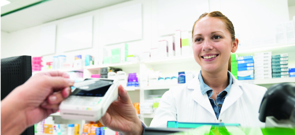 Customer paying with a credit card through a payment portal at a pharmacy.