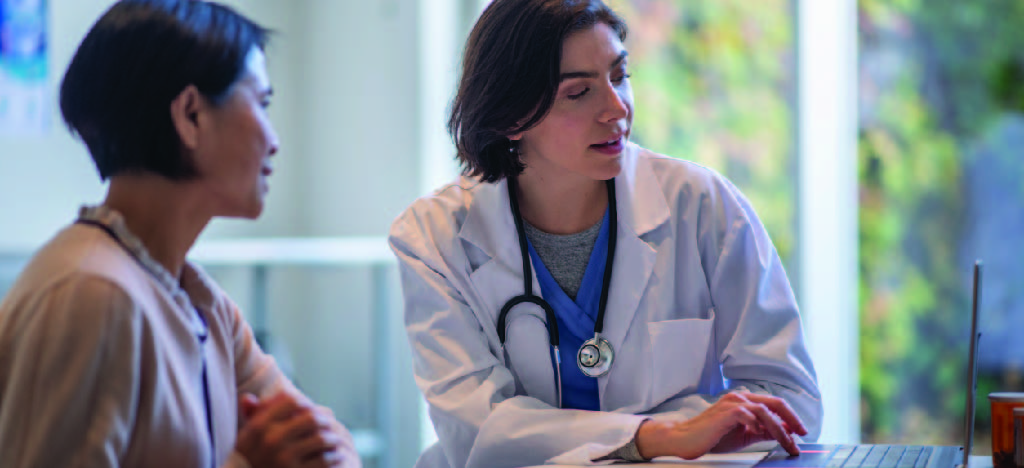 Improving patient experience - A female doctor assisting a female patient during a medical consultation.