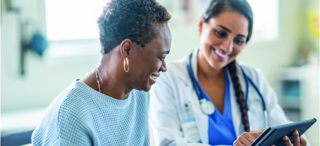 Protection against delayed payments - A female doctor using a tablet device to explain payment options to her female senior patient.