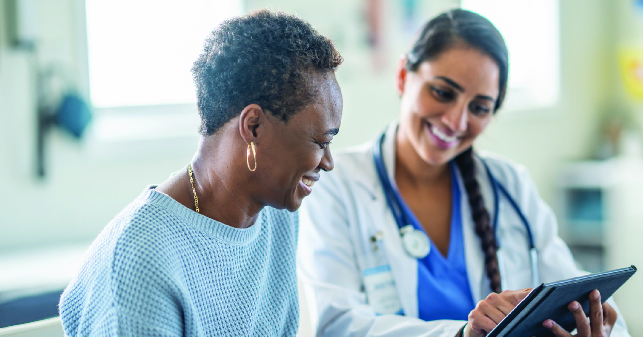 Protection against delayed payments - A female doctor using a tablet device to explain payment options to her female senior patient.