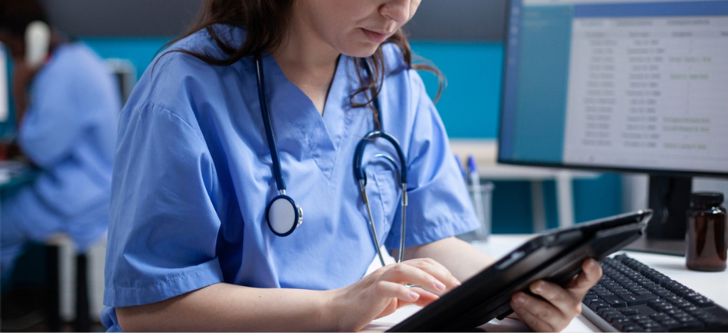 What is practice management software - A female hospital staff member using a tablet device to check for patient appointments.