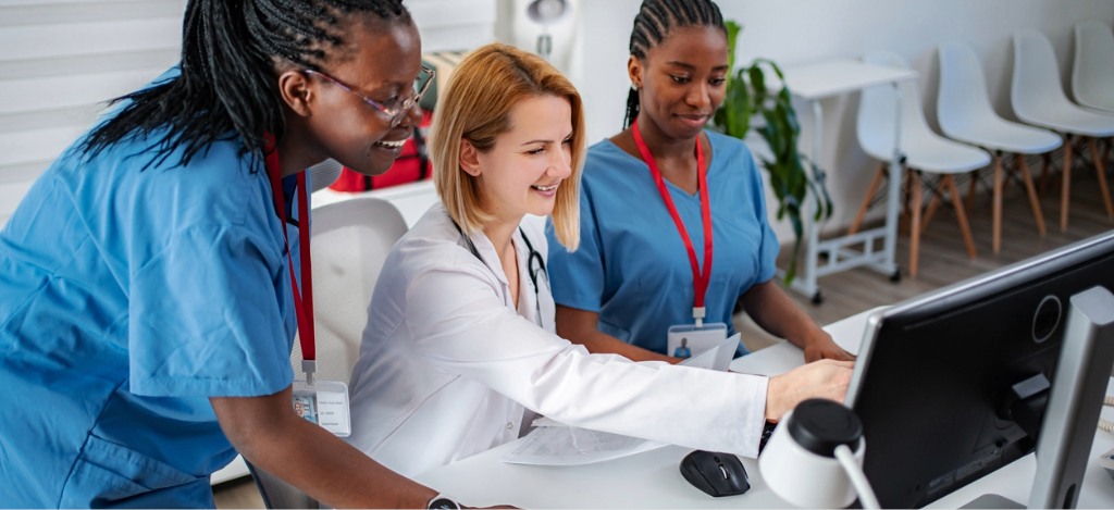 EHR integration - A group of medical professionals using a computer to check their practice’s EHR system.