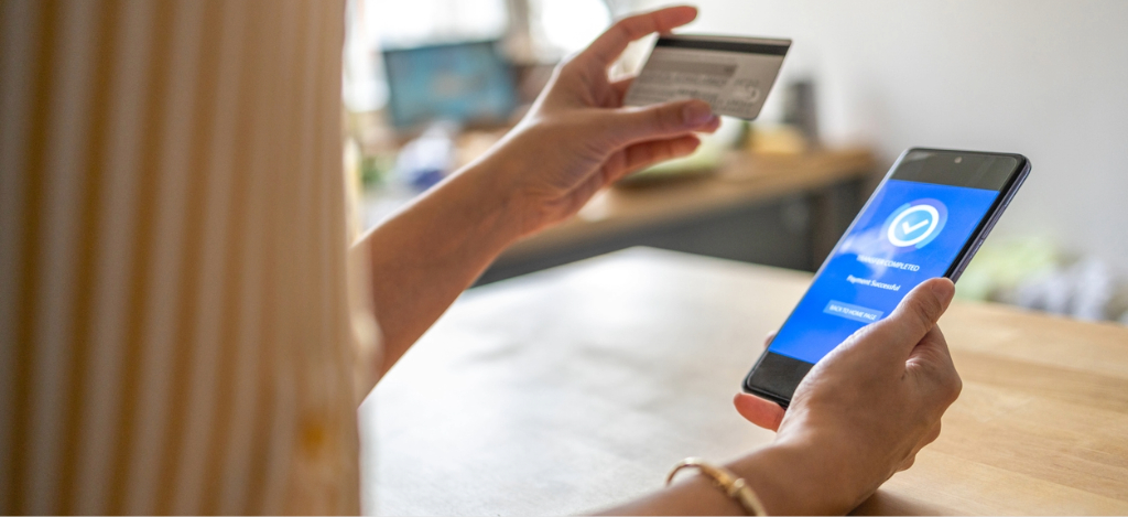 What is practice management software - A woman settling her medical bills using her credit card and smartphone.