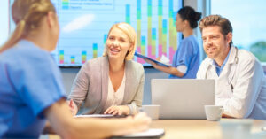RCM medical billing - A businesswoman discussing RCM services with a group of medical professionals.