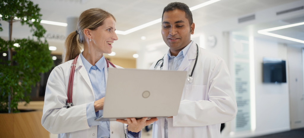 Medical office staff - Two doctors using a laptop to check their practice’s staff operations.