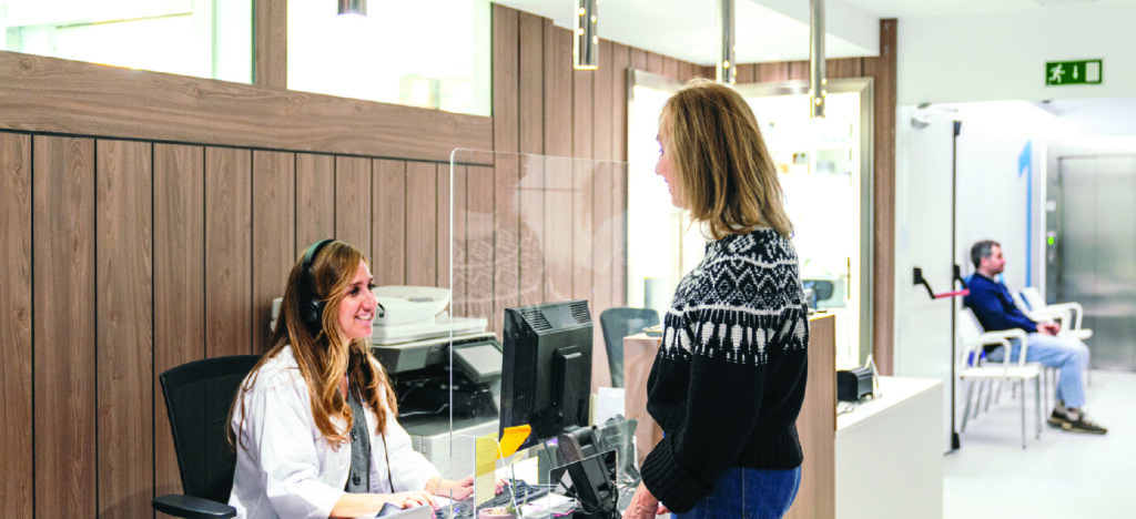 Female receptionist helping a patient at a medical facility.