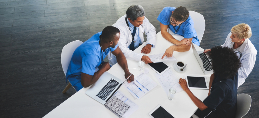 Implementing paper and electronic billing - A team of doctors in a conference room discussing their practice’s billing strategies.