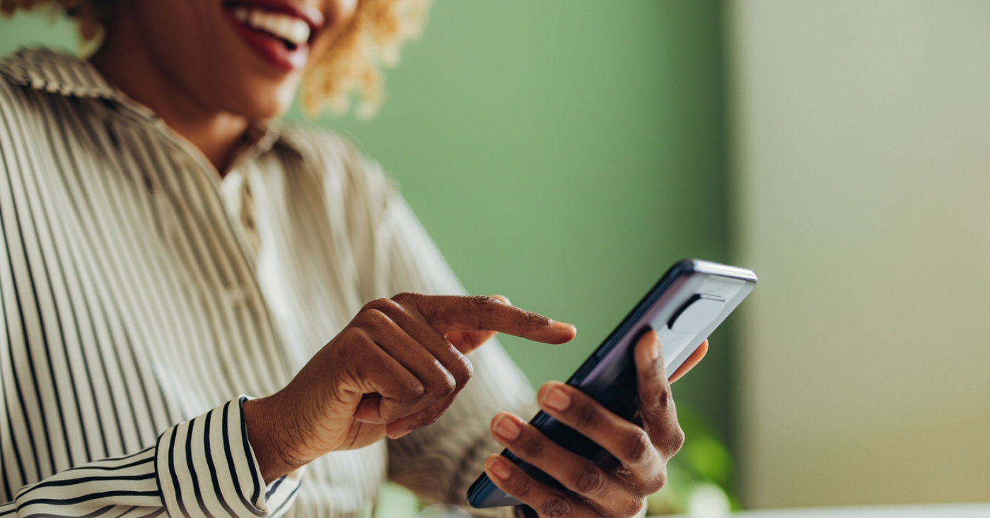 Automated patient billing - A woman at home using her smartphone to check for her medical bill payment reminder.