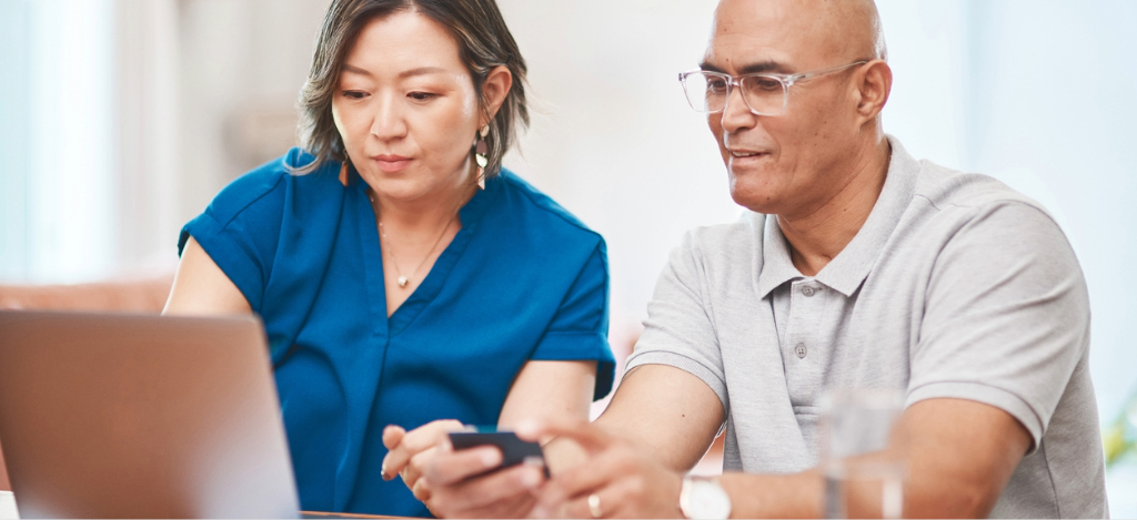 RCM company - An adult couple at home using their laptop and credit card to pay for their hospital bills.
