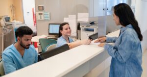 Using smart billing solutions for small practices - A hospital billing staff assisting a female patient in settling her medical bills.