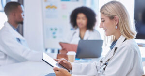 Private practice billing - A female doctor using a tablet device to check her practice’s revenue.