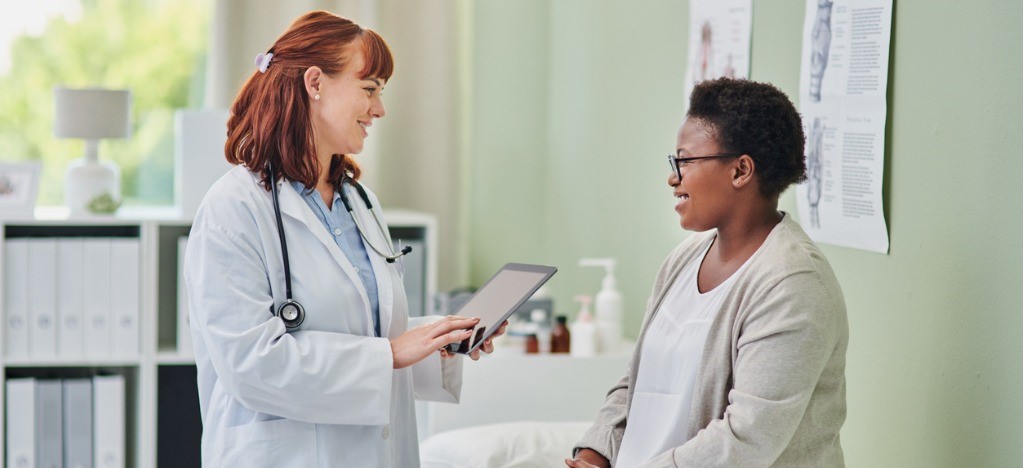 Improving accounts receivable in medical billing - A female doctor assisting a female patient during her medical appointment.