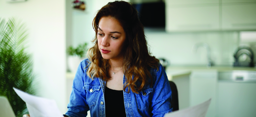 Improving patient financial responsibility - A woman reviewing a mailed medical bill.