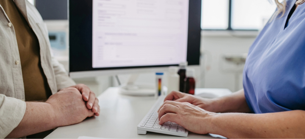 Electronic billing - A female hospital staff member entering a patient’s contact information into the hospital’s system.