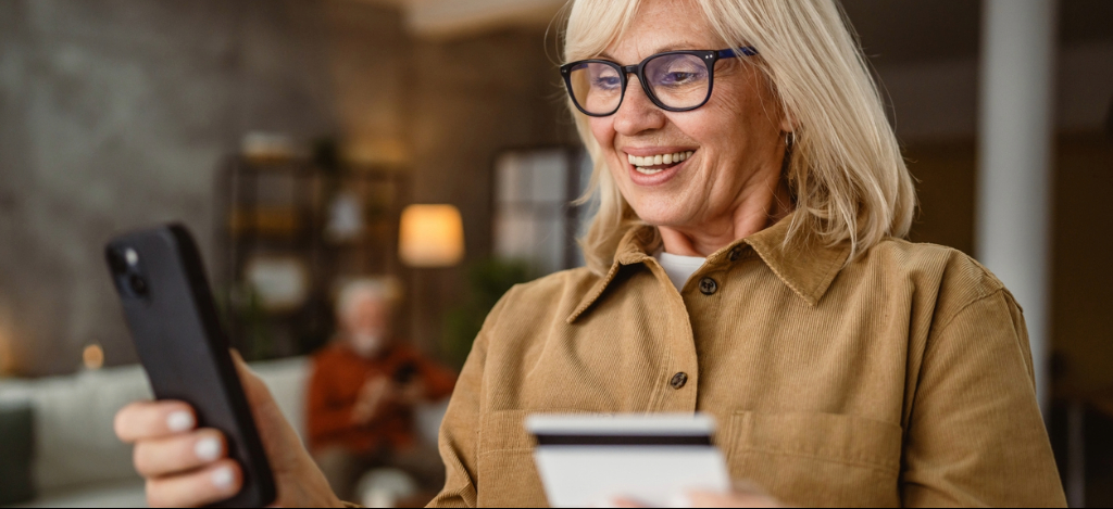 A mature woman using a smartphone to pay a bill online.