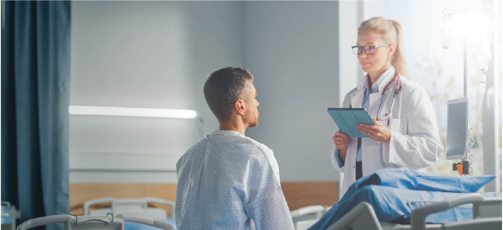 Flexible patient financing for medical procedures - A female doctor assisting a male patient in a hospital ward.