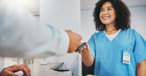 Patient payment plan - A female hospital staff member assisting a patient paying his medical bills using a credit card.