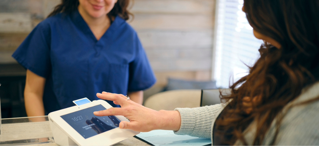 Types of payment methods - A female patient entering her PIN on a credit card terminal.