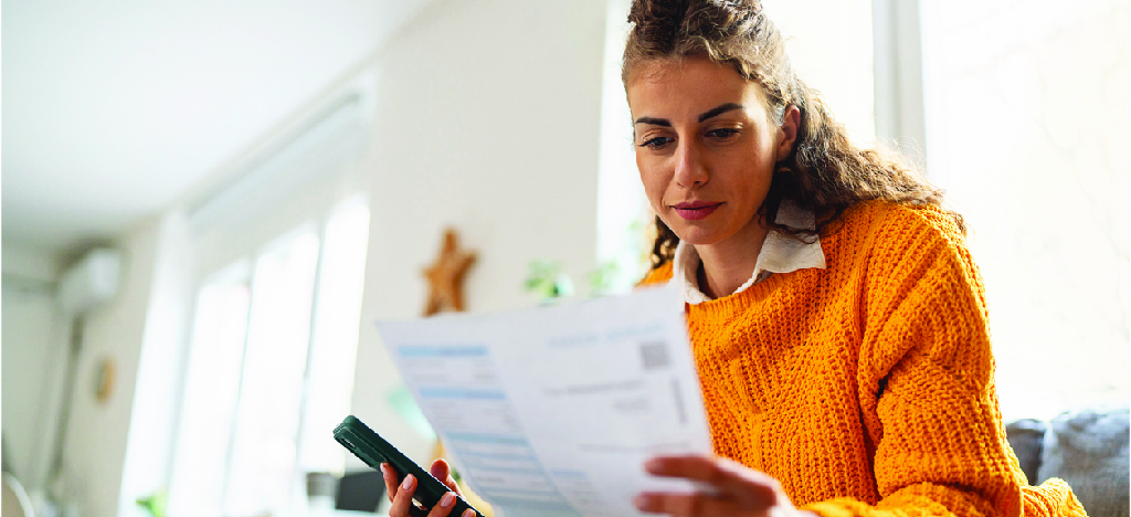 Personalized patient statement service - A woman at home reviewing her mailed medical bill.