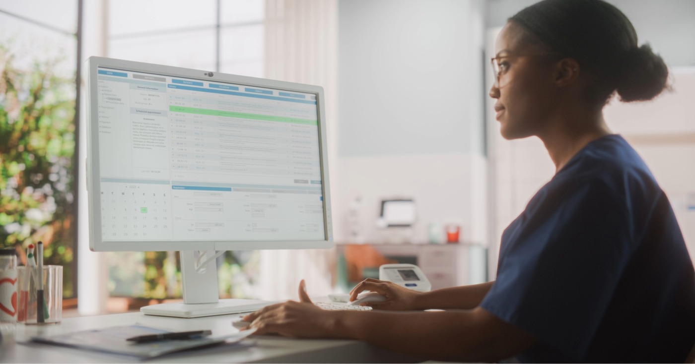 Preventing patient cancellations - A female medical professional using a computer to check for patient appointment schedules.