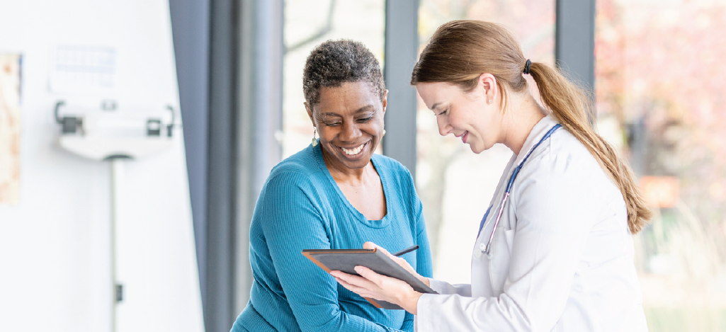 Responsibilities of medical billing managers - A female doctor writing down her patient’s information on a tablet device.