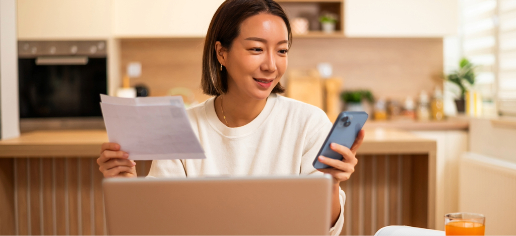 Medical billing issues - A woman at home using her smartphone to settle her medical bills online.