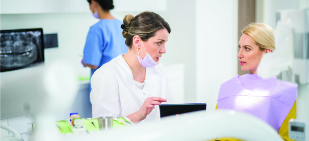 Providing dental patient financing - A female dentist in her clinic explaining dental treatment billing to her female patient.