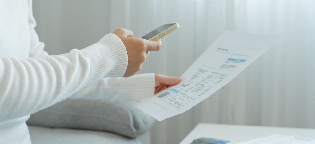 Medical billing technology solutions - A woman scanning her hospital bill’s QR code using a smartphone.