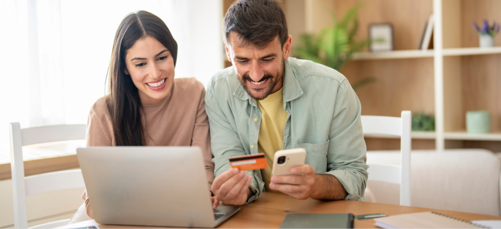 HIPAA-compliant text messaging - A couple at home viewing and paying their medical bills using their laptop and smartphone.