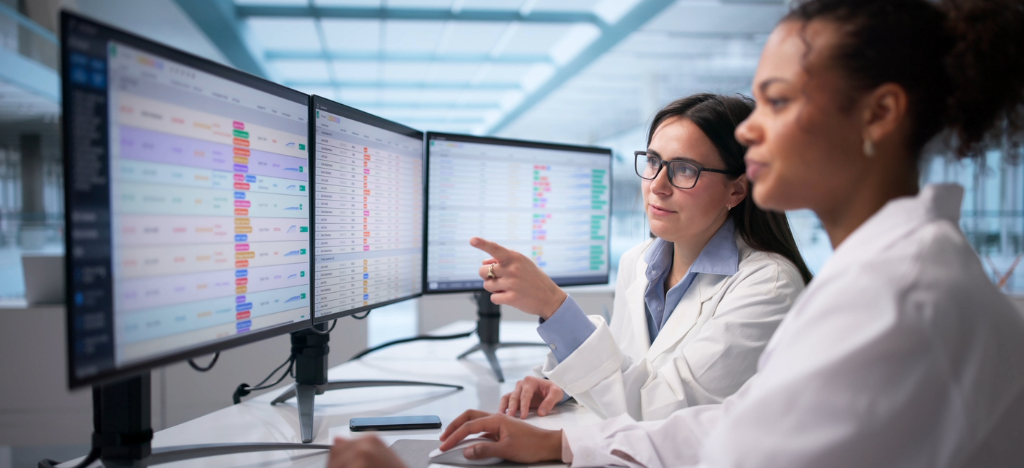 Revenue cycle partner - Two female medical professionals looking at patient bills on a computer.