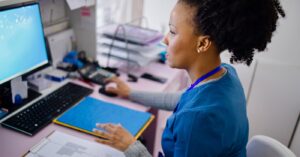 Reducing administrative burden - A female medical staff using a computer to check patient data.