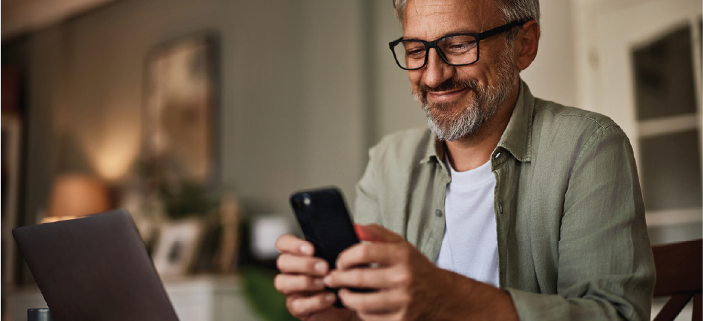 Efficient optometry billing solutions - A senior man checking a billing notification on his smartphone.