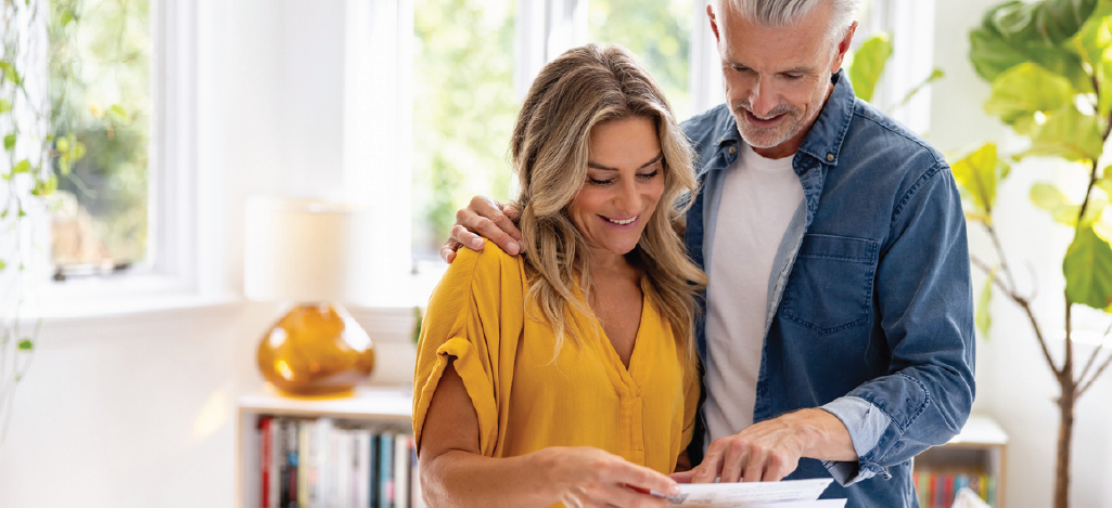 Modernized medical billing solutions - A mature couple at home checking their mailed medical statement.