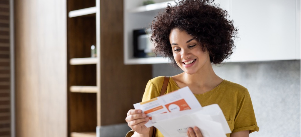 Improving your patient journey - A woman at home checking her mailed medical bill.