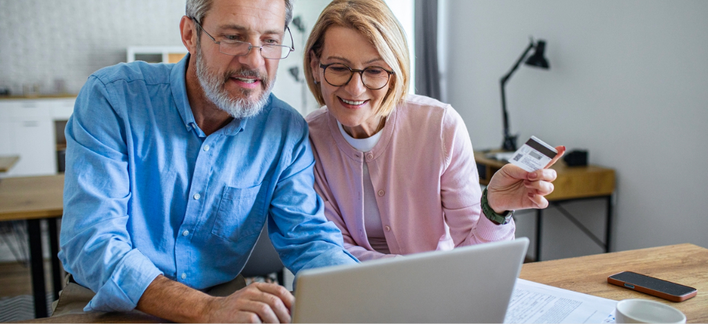 Best RPA software - A mature couple at home using a laptop to pay for their medical bills through an online portal.