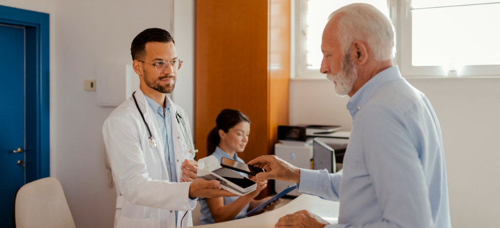 A senior man paying his medical bill using his smartphone.