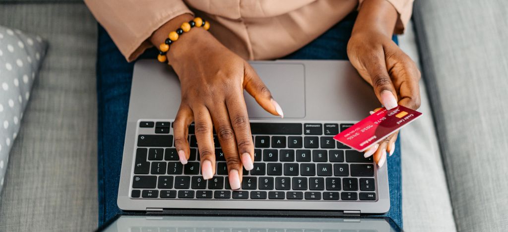 Patient Payment Experience: Top view of a woman paying with a credit card on a laptop.