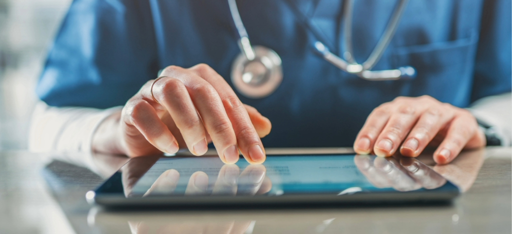 Revenue cycle vendors - A medical professional using a tablet device to access a medical billing platform.