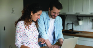 Utilizing pre-visit billing for medical practices - A couple at home checking their online medical bill using a laptop.